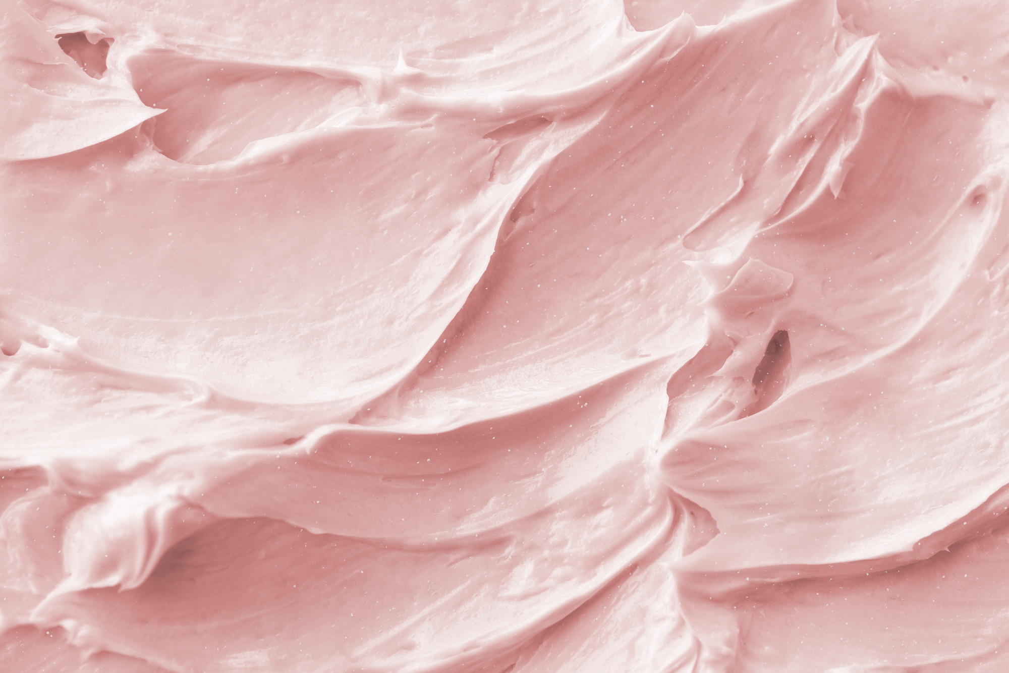 Gros plan sur la texture fouettée et rosée de la Chantilly de karité fruits rouges.
