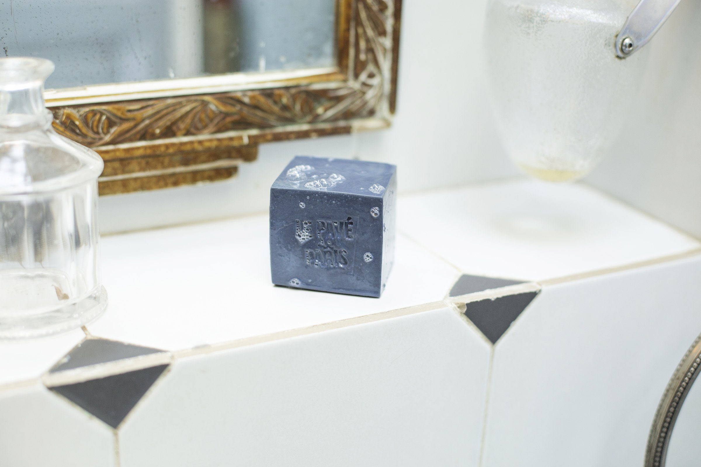 Vue 3 : Le pavé Le Bleu posé sur le rebord carrelé d'une salle de bain parisienne.